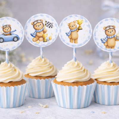 Cupcakes com cobertura branca e toppers redondos com desenhos de ursinhos em papel azul riscado.