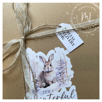 Embalagem castanha com fita bege, etiqueta com coelho e texto em inglês.