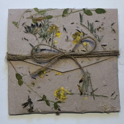 Envelope decorado com flores e folhas secas amarrado com cordão