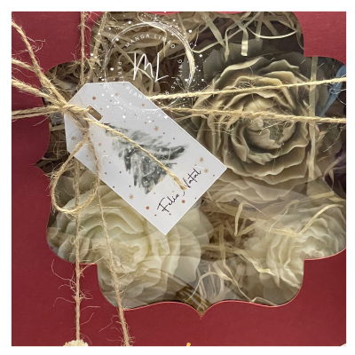 Caixa vermelha com flores decorativas e etiqueta de Feliz Natal