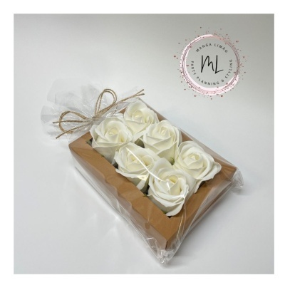 Caixa com seis flores brancas artificiais embalada em saco transparente com laço