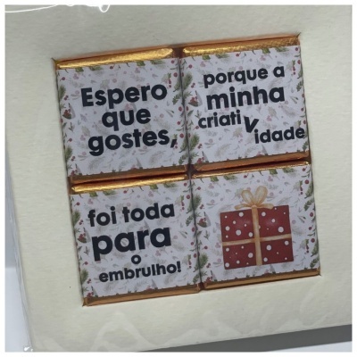 Quatro chocolates pequenos embalados com papel estampado e texto em português.