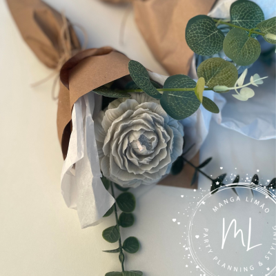 Bouquet com flor cinzenta artificial e folhas verdes, embrulho em papel castanho e branco, logótipo MANGA LIMÃO visível