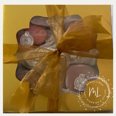 Caixa amarela com duas bolas decorativas e laço amarelo