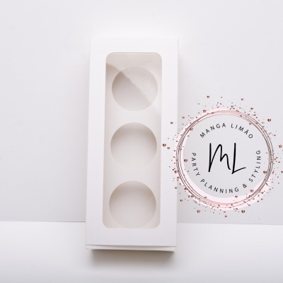 Caixa branca para ovos com três cavidades ao lado de cartaz decorativo