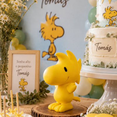 Festa de aniversário com bolo, doces e decoração do personagem Woodstock em tons amarelo, verde e branco
