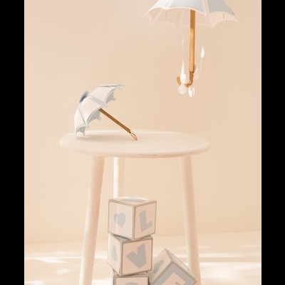 Dois guarda-chuvas brancos em madeira e blocos de madeira com letras LOVE sobre mesa branca e fundo bege.