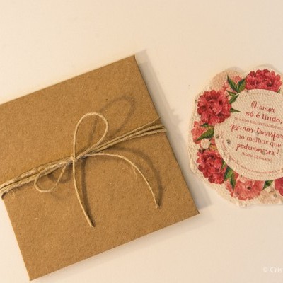 Cartão floral com envelope castanho e texto em português sobre fundo branco