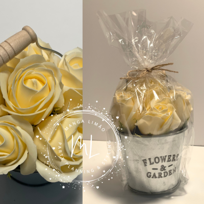 Mini vaso metálico com flores artificiais amarelas embalado em plástico transparente