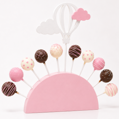 Cake pops decorados em suporte rosa com decoração de balão de ar quente e nuvens