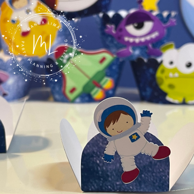 Suporte para guloseimas com astronauta de papel em fundo azul e decoração espacial