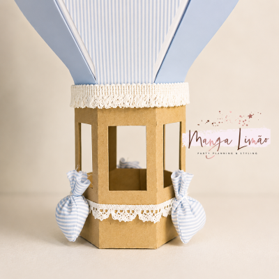 Balão decorativo de papel em azul claro e bege com renda branca e almofadas de tecido às riscas