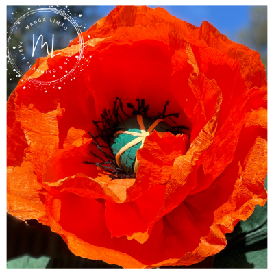 Flor artificial vermelha com pétalas texturizadas e miolo azul em fundo desfocado