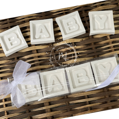 Cubos brancos com letras em relevo formando a palavra BABY em superfície de vime