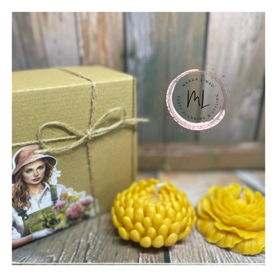 Caixa amarela com laço de juta e velas amarelas em formato de flores sobre madeira