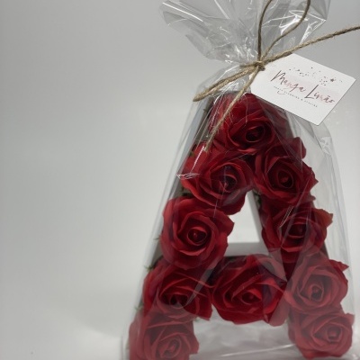 Arranjo letra A com rosas vermelhas em embalagem plástica transparente