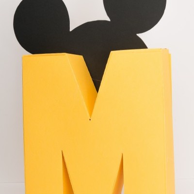 Estrutura amarela em forma de letra M com forma preta atrás similar a cabeça do Mickey Mouse