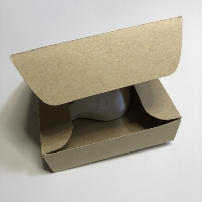 Caixa de cartão castanho aberta com objeto branco dentro