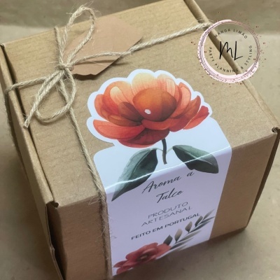 Caixa de cartão castanho com etiqueta branca e flor vermelha