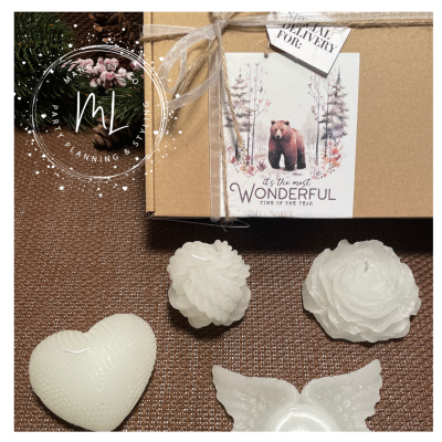 Velas decorativas brancas em vários formatos e caixa de presente com etiqueta de urso