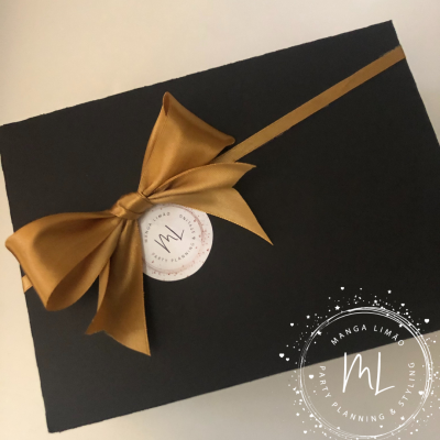 Caixa preta com laço castanho dourado e adesivo branco MANGA LIMÃO