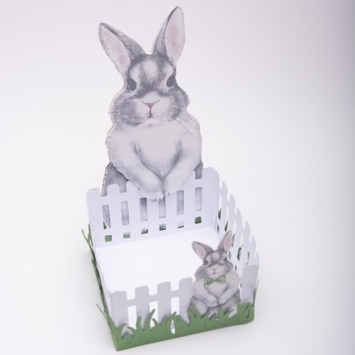 Caixa decorativa com coelhos cinzentos e relva verde