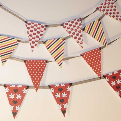 Varal de bandeirolas coloridas com padrões de riscas, bolinhas e mãos com orelhas de rato