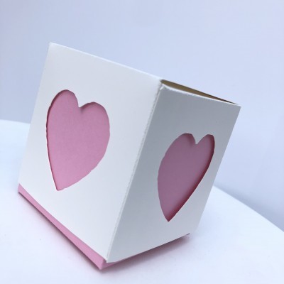 Caixa branca com coroações recortadas e interior cor-de-rosa