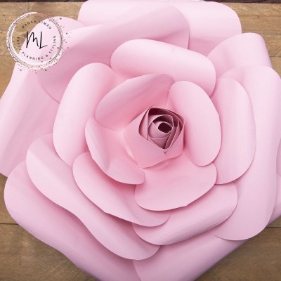 Flor decorativa rosa com grandes pétalas, fundo madeira clara