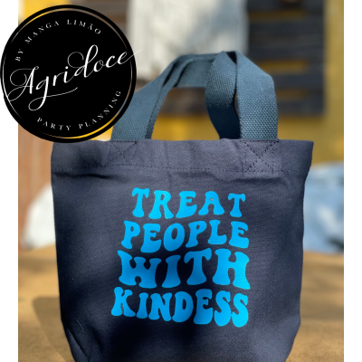 Saco preto com texto azul claro 'TREAT PEOPLE WITH KINDESS' em tecido, com alças curtas.