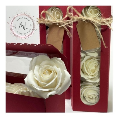 Flores artificiais brancas em caixa vermelha com tampa transparente e laço de corda.