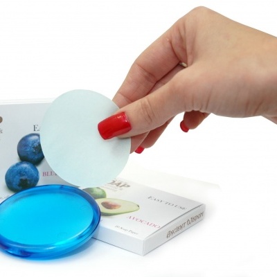 Sabonete em papel azul transparente com folha redonda branca e embalagens com mirtilos