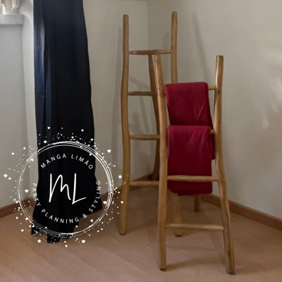 Duas escadas decorativas de madeira clara com um pano vermelho pendurado