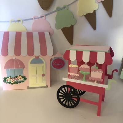 Miniaturas em papel de carrinho de bolos e casinha decorativa com flores e bandeirolas de gelados