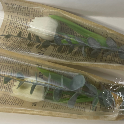 Duas flores artificiais embrulhadas em papel de jornal