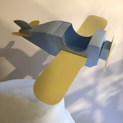 Modelo infantil de avião em papel cinzento com asas amarelas