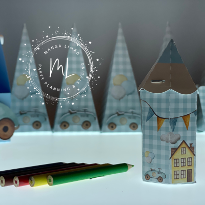 Caixas decorativas em forma de casinhas com padrão xadrez azul e ilustrações coloridas, sobre superfície branca com lápis coloridos