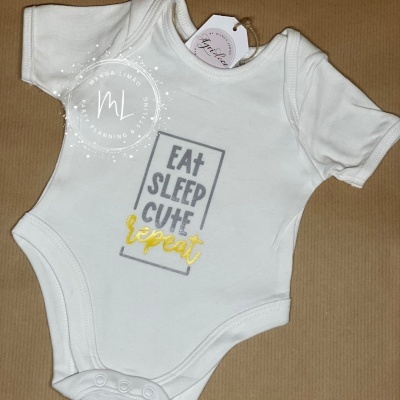 Body branco para bebé com texto estampado em cinzento e amarelo