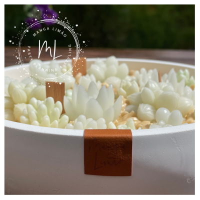 Frasco branco grande com rótulo castanho contendo velas brancas em forma de flores