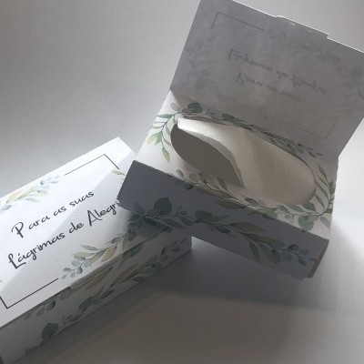Caixas decoradas com folhas verdes, uma aberta contendo lenço branco