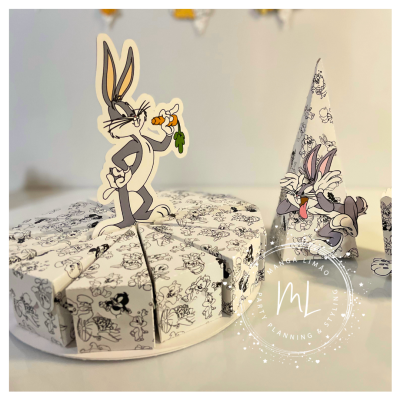 Caixas em forma de fatias de bolo com desenhos do Pernalonga em preto e branco e recorte colorido do personagem segurando uma cenoura.