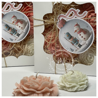 Velas decorativas em forma de flor rosa e branca embaladas em caixas brancas com etiqueta Natal