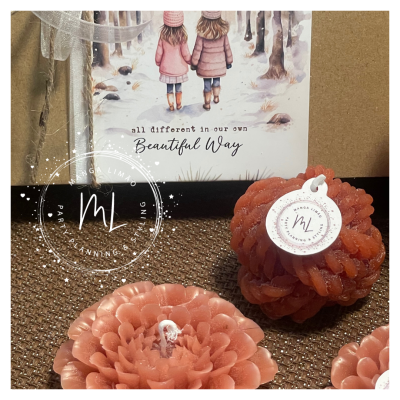 Velas rosa em formato de flor com etiqueta ML e cartão decorativo ao fundo