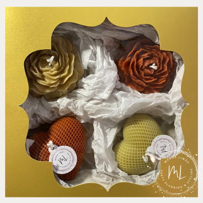 Conjunto de velas decorativas em embalagem dourada com janela transparente.