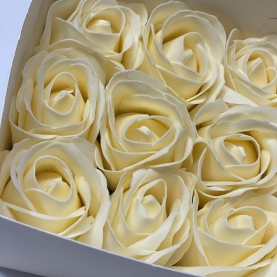 Caixa branca com velas creme em forma de rosas grandes