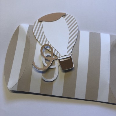 Envelope decorativo bege com balão de ar quente e letras DG em cartolina