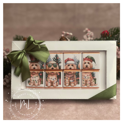 Caixa branca com laço verde e chocolates ilustrados com cães natalícios