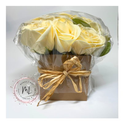 Buquê de rosas amarelas artificiais num saco plástico dentro de caixa castanha com laço