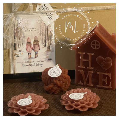 Várias velas decorativas castanhas e casa decorativa com letras H O M E e cartão com texto Snowflake.