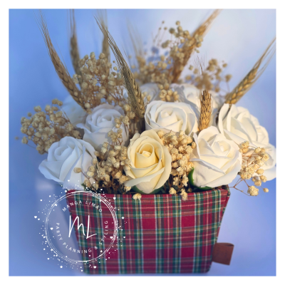 Arranjo floral com rosas brancas e espigas em vaso riscado vermelho e verde